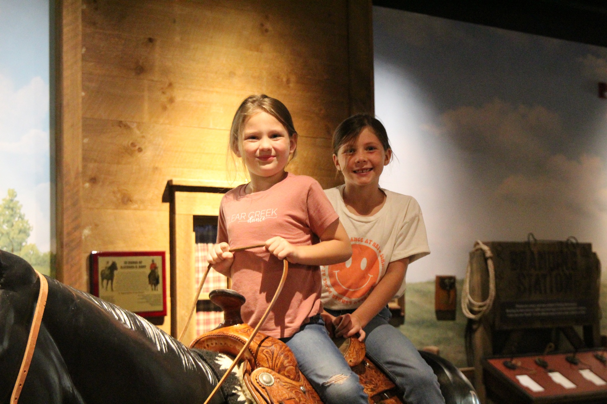 Photo of children posing on model horse