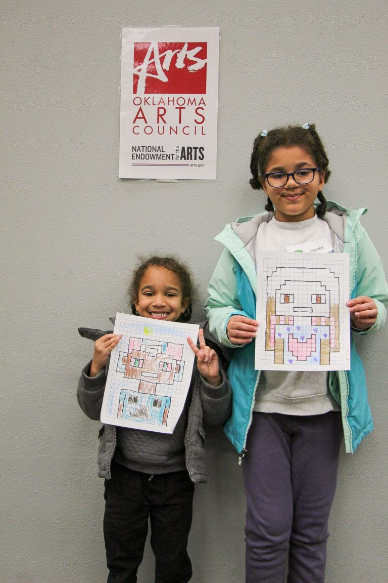 Photo of children posing with their artwork